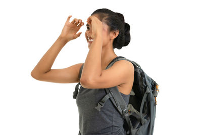 Young woman drinking against white background