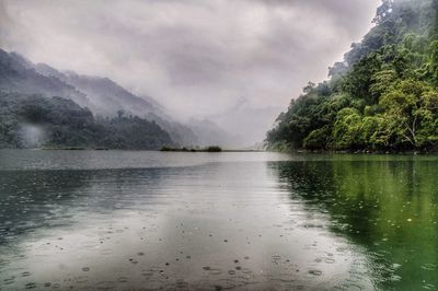 Scenic view of lake against sky during rainy season