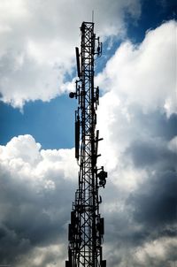 Low angle view of crane against cloudy sky