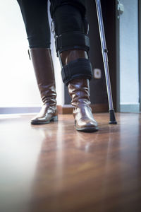 Low section of handicapped man with walking cane standing on parquet floor