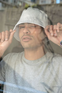 Portrait of young man holding hat