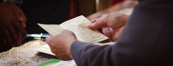 Midsection of couple holding book