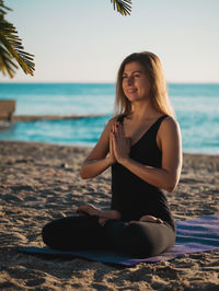 Woman doing yoga at beach