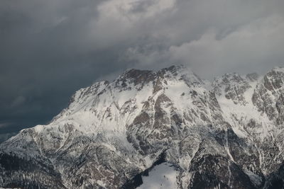 Low angle view of snowcapped mountains against sky