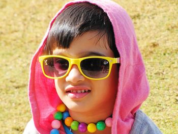 Close-up of cute girl wearing eyeglasses on field