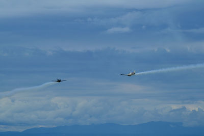 Low angle view of airplanes flying in sky