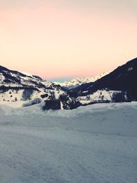 Scenic view of snow covered mountains against sky during sunset