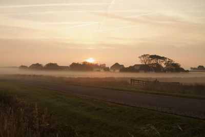 Scenic view of field against sky during sunset