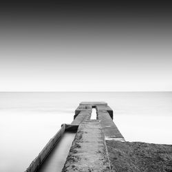 Pier amidst sea against sky during foggy weather