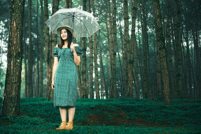 Full length of woman standing in forest