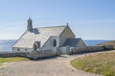 Exterior of building by sea against sky