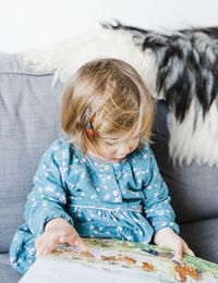 Close-up of cute girl reading book at home