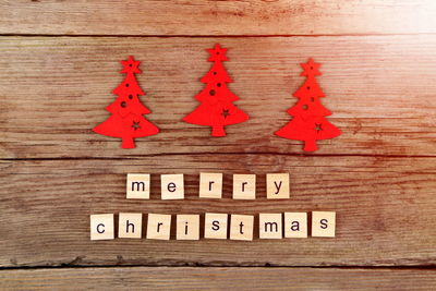 Close-up of text on wooden blocks with artificial christmas tree at table