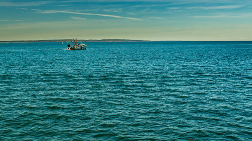 Boat sailing in sea against sky during sunset