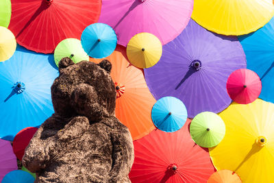 Low angle view of multi colored umbrellas against blue sky