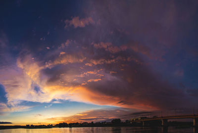 Storm clouds over city during sunset