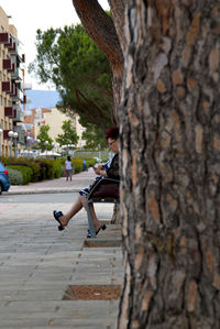 Side view of woman sitting in park