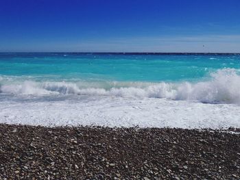 Scenic view of beach against blue sky