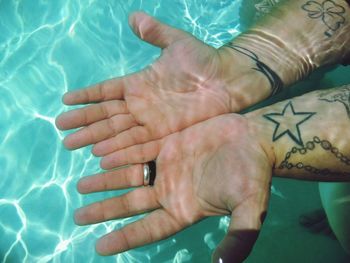 High angle view of woman hand in swimming pool