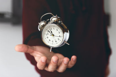 Close-up of person holding clock