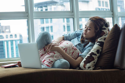 Rear view of women sitting on laptop