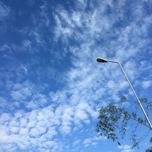 Low angle view of street light against cloudy sky