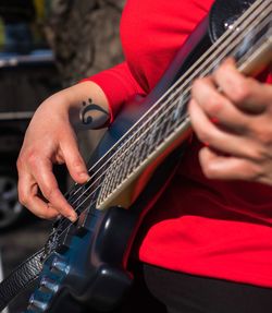 Midsection of woman playing guitar