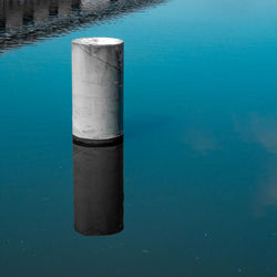 High angle view of concrete bollard in blue lake