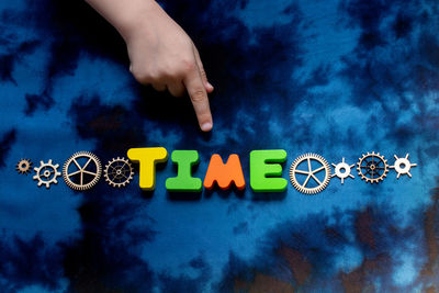 Midsection of person playing with toys against blue wall