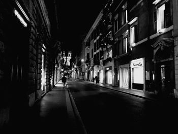 Street amidst buildings in city at night