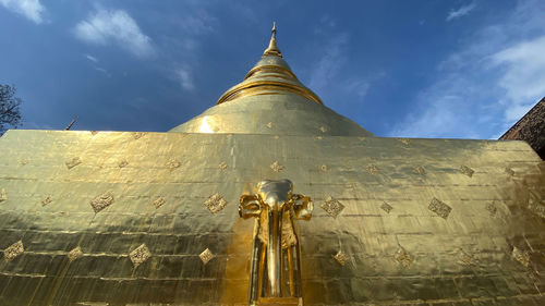 Low angle view of statues on building against sky