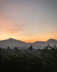 Scenic view of silhouette mountains against sky at sunset