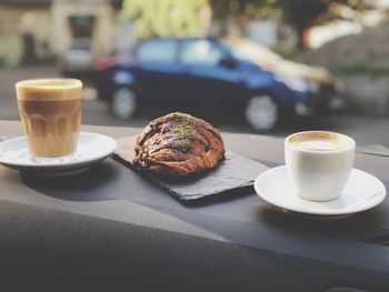 Croissant amid coffees served on table
