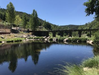 Arch bridge over lake against sky