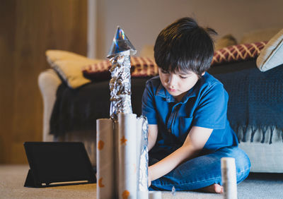 Cute boy making craft at home