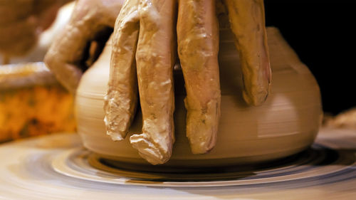 Cropped hand making pots at workshop