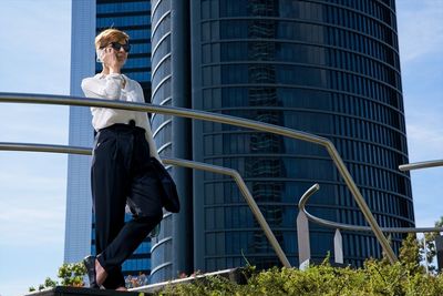 Low angle view of woman looking at building