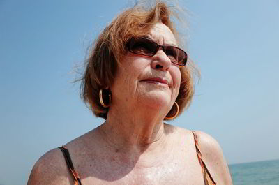Close-up senior woman wearing sunglasses against clear sky