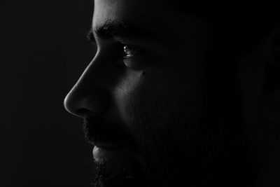 Thoughtful man against black background