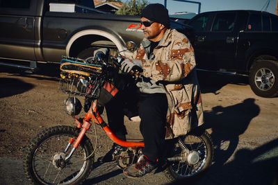 Man with bicycle standing on street in city