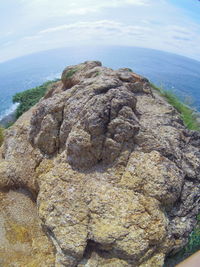 Close-up of rock formation in sea against sky
