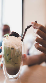 Cropped hands of woman holding dessert in restaurant