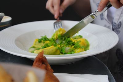 Midsection of woman preparing food in plate