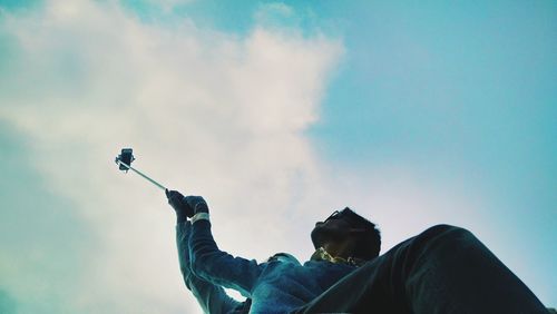 Low angle view of people against blue sky