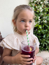 Side view of young woman blowing bubbles at home