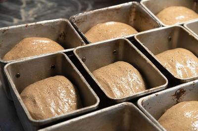Uncooked bread in the form of dough is placed in bread tins before baking. craft bread.