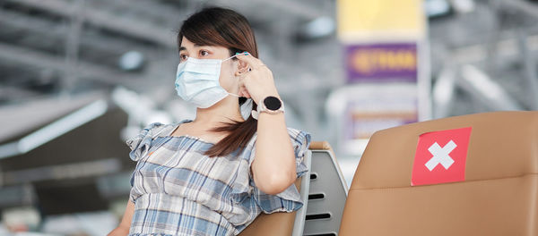 Portrait of woman with mobile phone while standing on bus