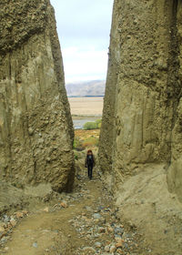 Rear view of man and woman walking on rock