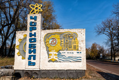 Information sign on road against blue sky