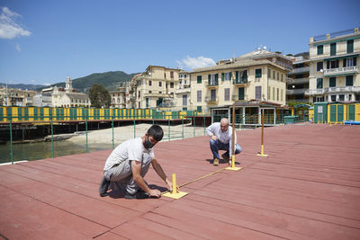 Full length of boys on building against sky